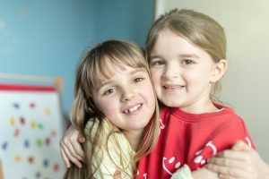 Two young sisters hugging